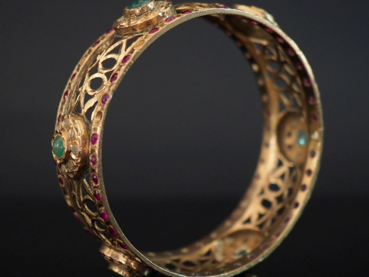 Bracelet jonc en or jaune 750, à décor ajouré agrémenté de six médaill