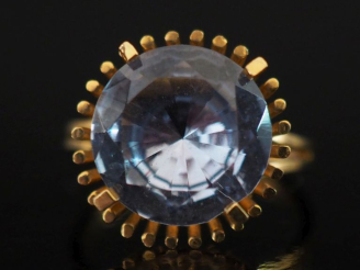 Vente aux enchères Bague en or jaune 750, sertie en son centre d'une pierre bleu ciel. Jo