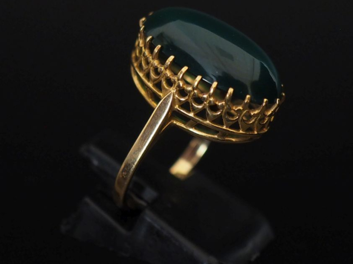 Bague en or jaune 750, sertie en son centre d'une pierre verte en cabo