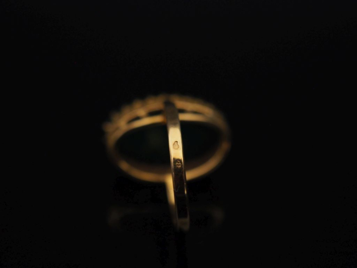 Bague en or jaune 750, sertie en son centre d'une pierre verte en cabo