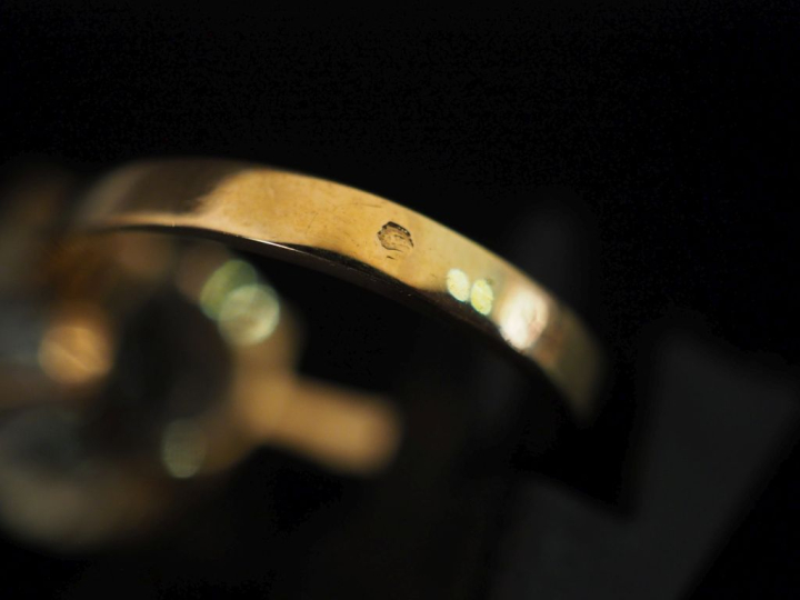 Bague en or jaune 750, sertie en son centre d'une pierre jaune pâle.  