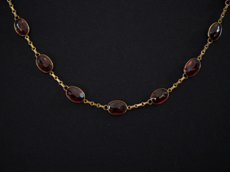Vente aux enchères Collier souple en or jaune 750, serti de grenats (?). Long. 45,5 cm Po