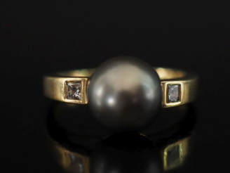 Vente aux enchères Bague en or jaune 750, sertie en son centre d'une perle grise épaulée 