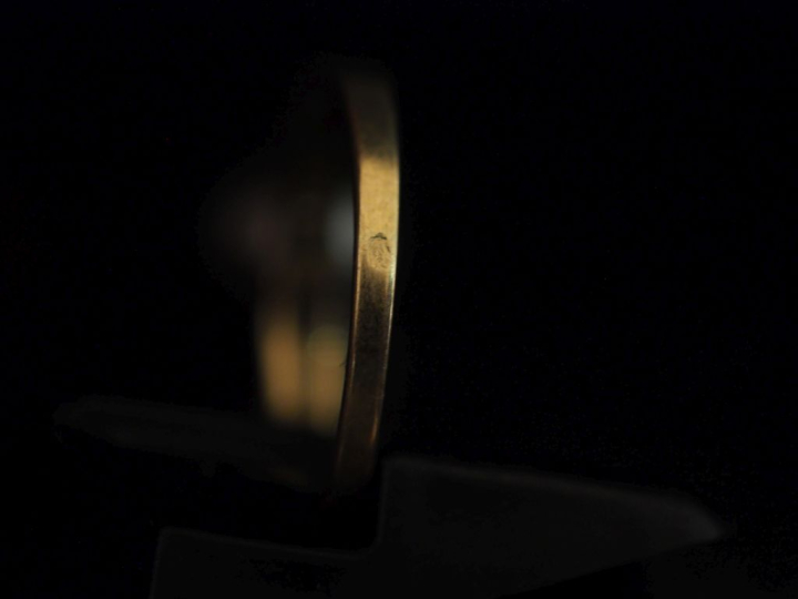 Bague en or jaune 750, sertie en son centre d'une perle grise épaulée 