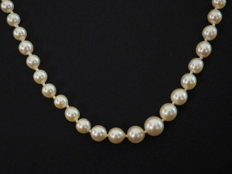 Vente aux enchères Collier de perles blanches disposées en chute.  Fermoir en or blanc 75