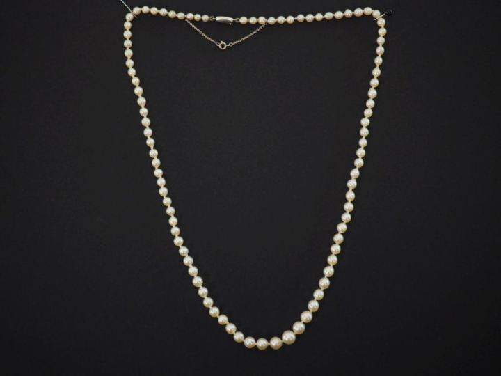 Collier de perles blanches disposées en chute.  Fermoir en or blanc 75