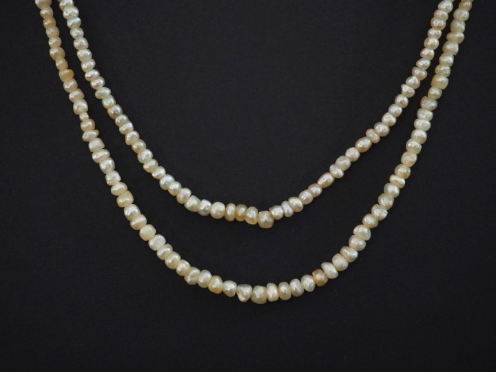Ensemble comprenant :  - un collier de perles blanches de forme baroqu