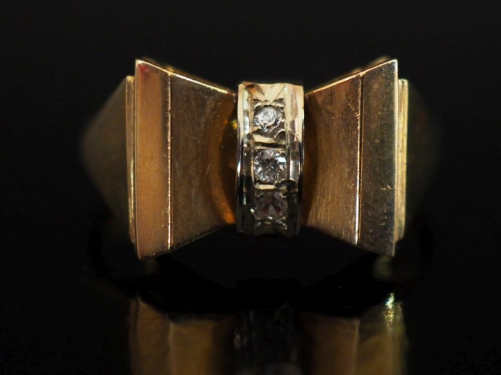 Bague nœud en or jaune 750, sertie en son centre d'une ligne de trois 