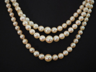 Vente aux enchères Collier triple rangs de perles blanches disposées en chute.  Fermoir e