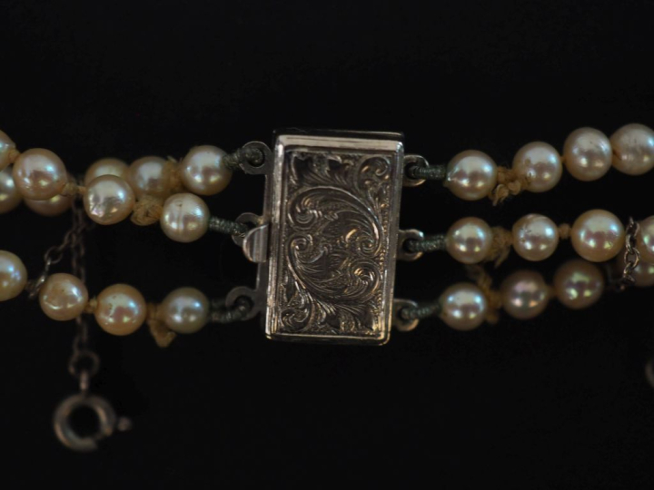 Collier triple rangs de perles blanches disposées en chute.  Fermoir e