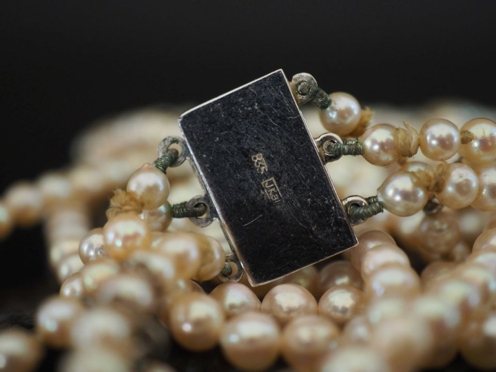 Collier triple rangs de perles blanches disposées en chute.  Fermoir e