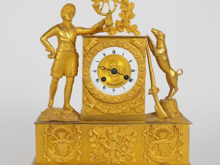 Pendule borne Restauration en bronze doré à décor de chasseur, de son 
