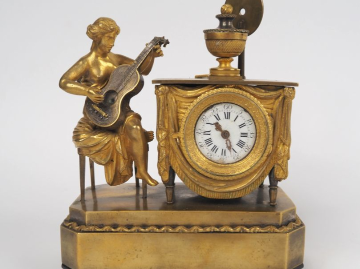 Pendulette musicale de style Directoire en bronze doré, à décor de jeu