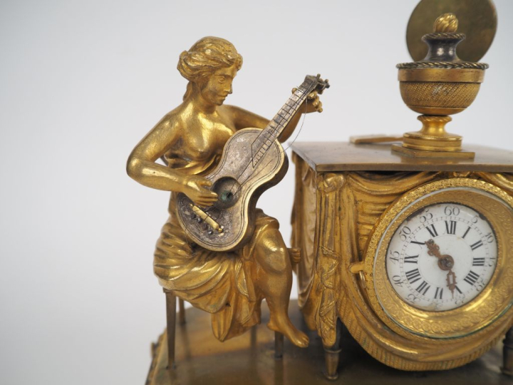 Pendulette musicale de style Directoire en bronze doré, à décor de jeu