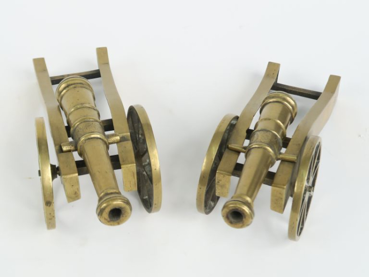 Deux canons d'artillerie miniatures 1900 en bronze sur leurs supports.