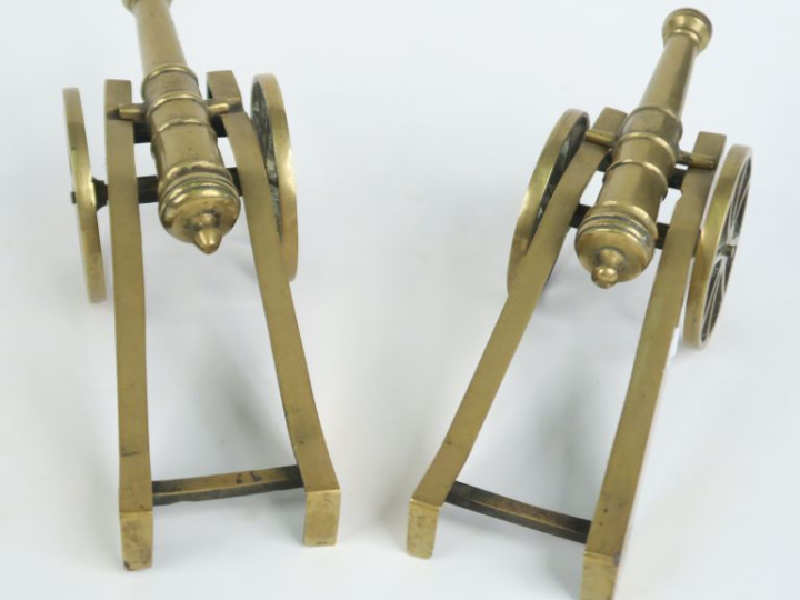 Deux canons d'artillerie miniatures 1900 en bronze sur leurs supports.