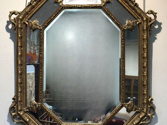 Grande glace de salon à parecloses en bois et stuc doré, à décor de fe