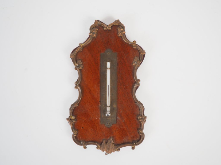 Thermomètre en bois et laiton de style Louis XV. Dim. 17 x 9,5 cm.