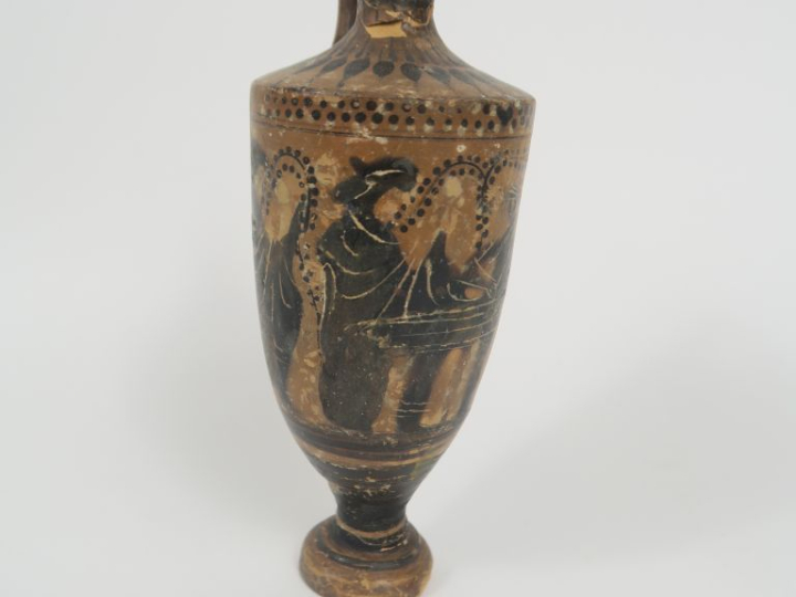 Vase grec. Lécythe à figures noires figurant des femmes autour d’une t