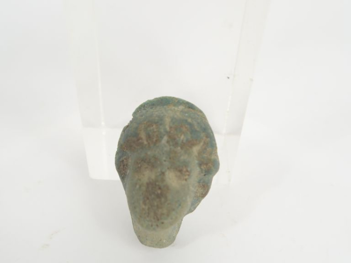 Pendentif en forme de tête antique en matière vitreuse. 3,5 x 2,5 cm