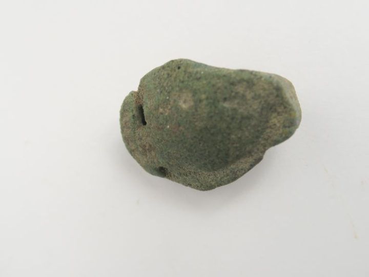 Pendentif en forme de tête antique en matière vitreuse. 3,5 x 2,5 cm