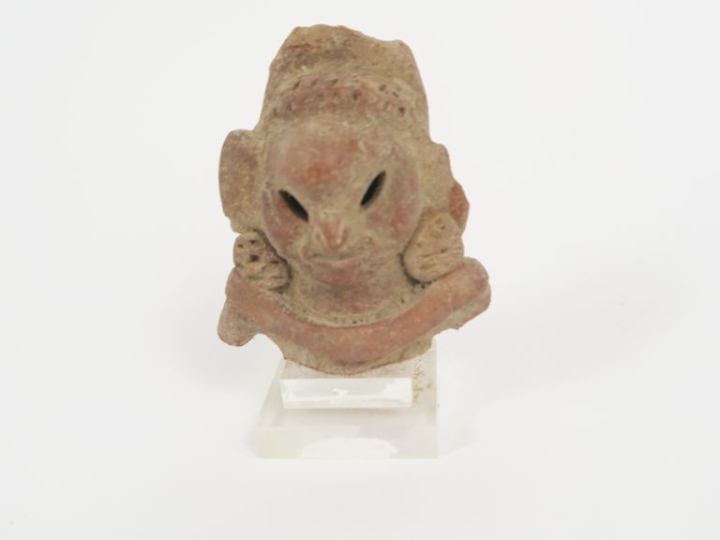 Tête de figurine antique en terre cuite. 9 x 6,5 cm.