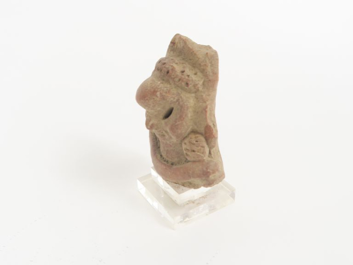 Tête de figurine antique en terre cuite. 9 x 6,5 cm.