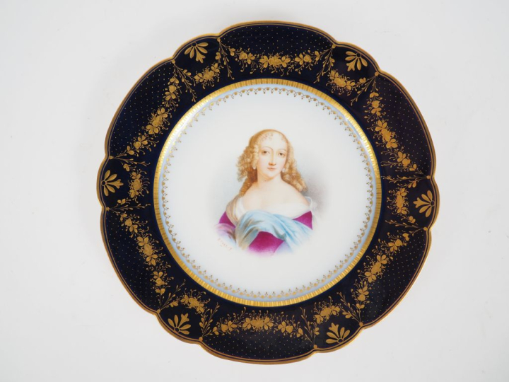SEVRES.  Assiette en porcelaine à décor polychrome de jeune fille. Sig