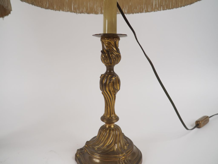 Deux différents bougeoirs de style Louis XV en métal, montés en lampe.