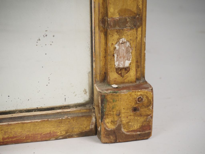 Glace XIXème de style Empire, cadre en stuc doré à décor de pilastres 