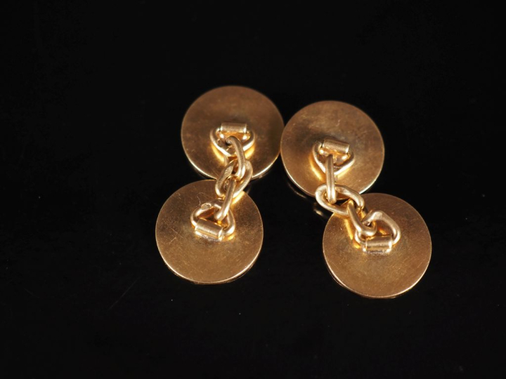 Paire de boutons de manchettes en or jaune 750, à décor ondulé.  Diam.