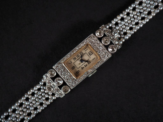Vente aux enchères Montre de dame Art Déco, boitier en platine entouré de diamants, brace