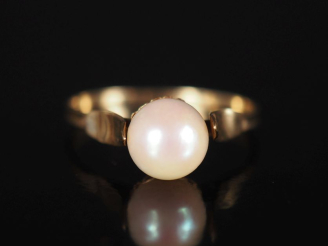 Vente aux enchères Petite bague en or jaune 750, sertie en son centre d'une perle.  TDD. 