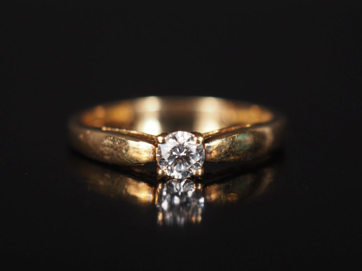 Bague de forme solitaire en or jaune 750, sertie en son centre d'un pe