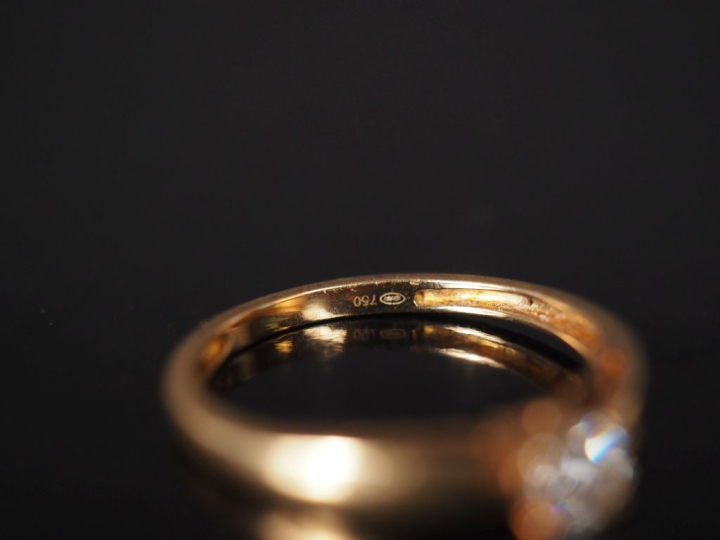 Bague de forme solitaire en or jaune 750, sertie en son centre d'un pe