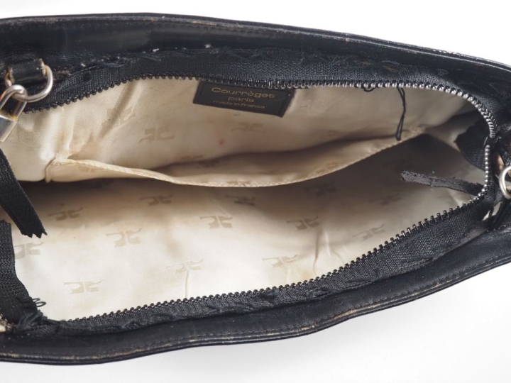 COURREGES, Paris Pochette en cuir noir.  Fermeture à zip, découvrant u