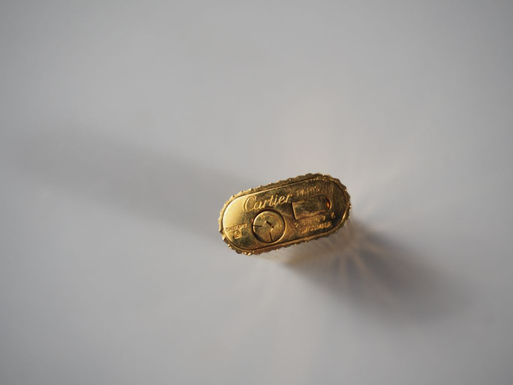 CARTIER, Must Briquet en métal doré, à décor de cannelures. Signé.  Nu