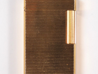 Vente aux enchères Briquet Dupont en métal doré, à décor de stries.  Signé.