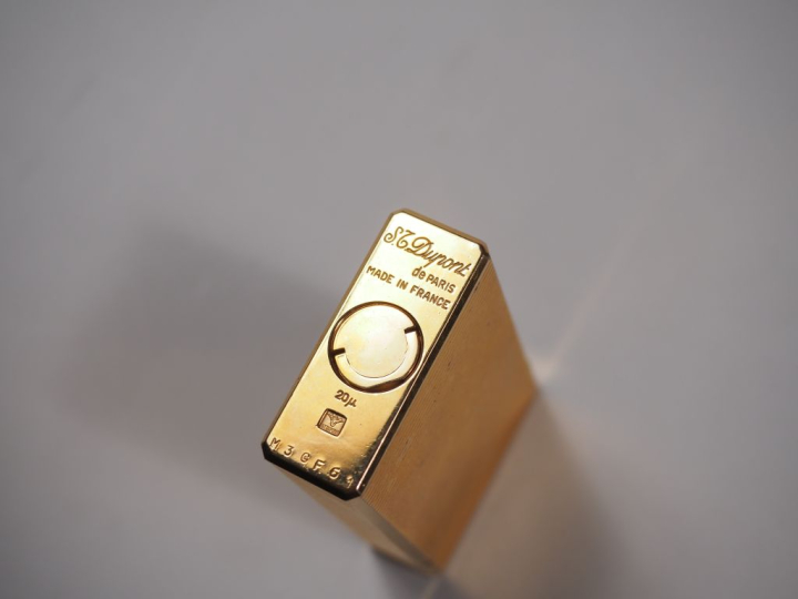 Briquet Dupont en métal doré, à décor de stries.  Signé.