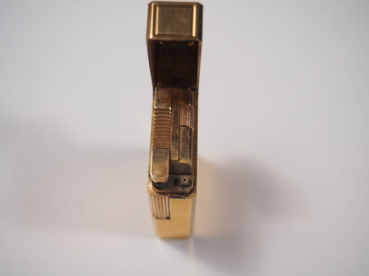 Briquet Dupont en métal doré, à décor de stries.  Signé.