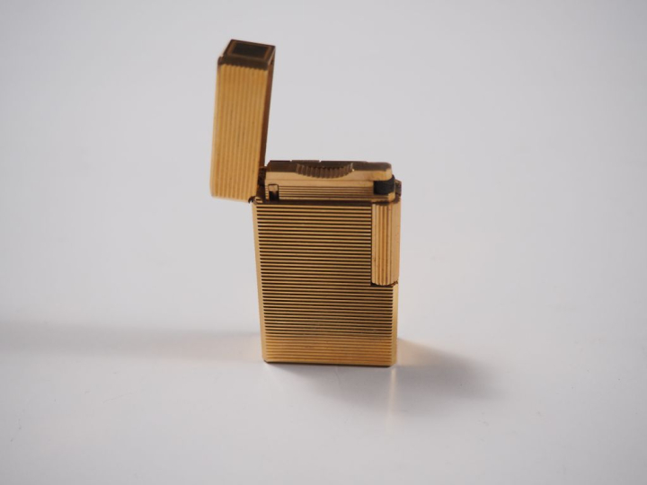 Briquet Dupont en métal doré, à décor de stries.  Signé.
