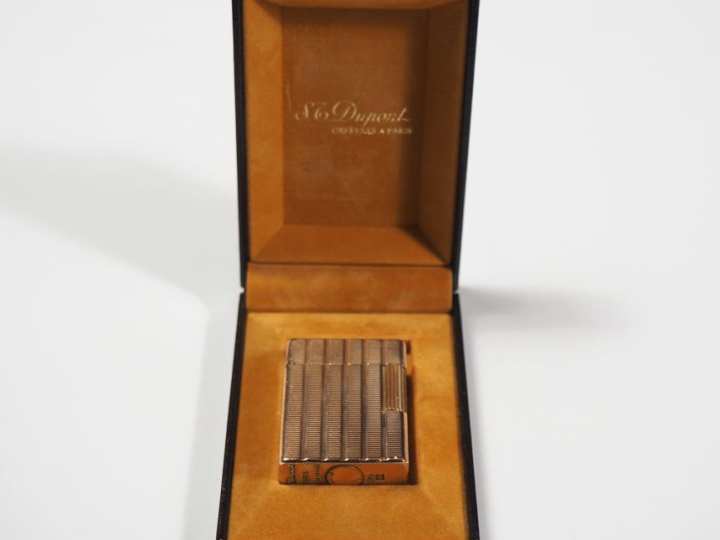 Briquet Dupont en métal doré, à décor de stries. Signé.  4,8 x 3,6 cm 