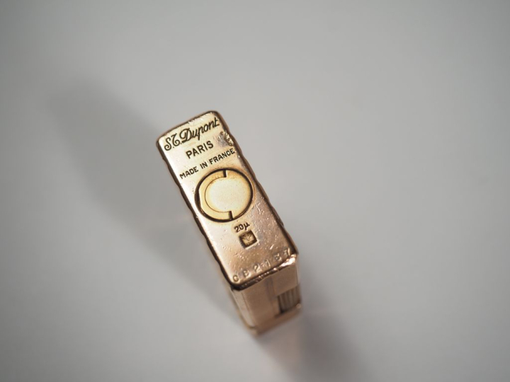 Briquet Dupont en métal doré, à décor de stries. Signé.  4,8 x 3,6 cm 