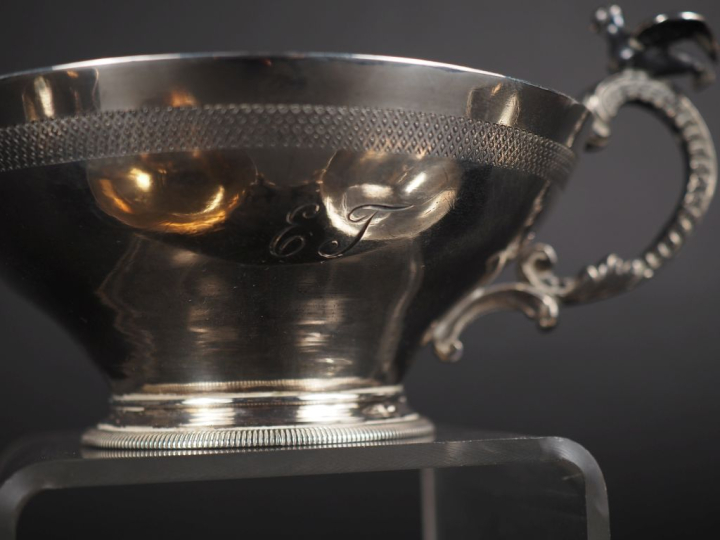 4 coupes à anses et une tasse en argent à décor d'oiseaux, et une tass