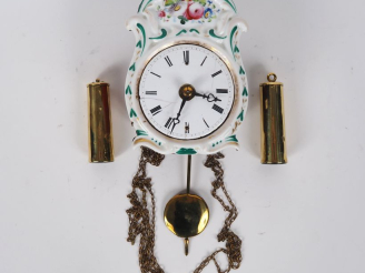 Vente aux enchères Pendulette murale en porcelaine à décor de fleurs polychrome, cadran é