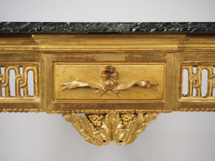 Console Louis XVI en bois sculpté doré et ajouré à décor de cannelures