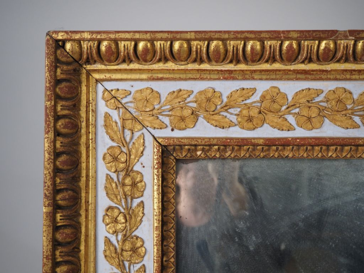 Glace XIXème en bois et stuc doré, à décor de frises de fleurs sur fon