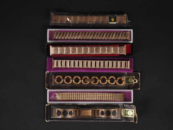 Ensemble comprenant sept différents bracelets de montre en métal doré 