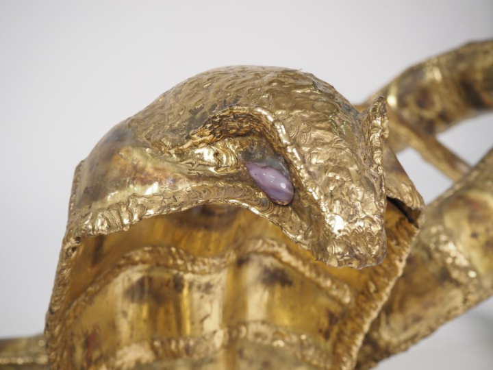 Henri FERNANDEZ. Table basse lumineuse "cobra" en laiton doré, les yeu