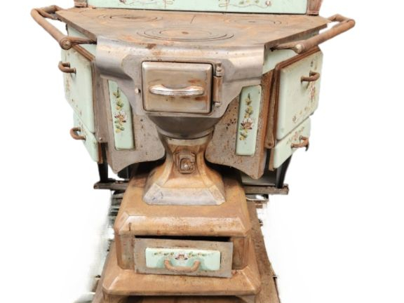 Cuisinière ancienne à décor émaillé de fleurs sur fond vert.